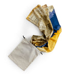 The Historic Philadelphia Then Scarf, featuring a city map design in yellow, blue, and brown, is partially pulled out of a beige drawstring pouch.