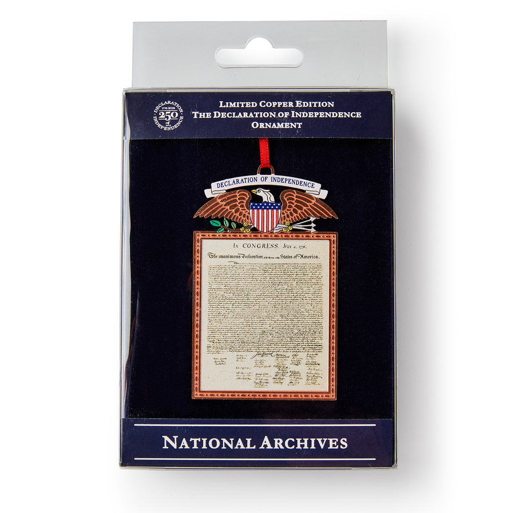 The Declaration Copper Ornament features the Declaration of Independence, an eagle with a shield, and is labeled “Limited Copper Edition” and “National Archives.” It hangs on a red ribbon inside its packaging.