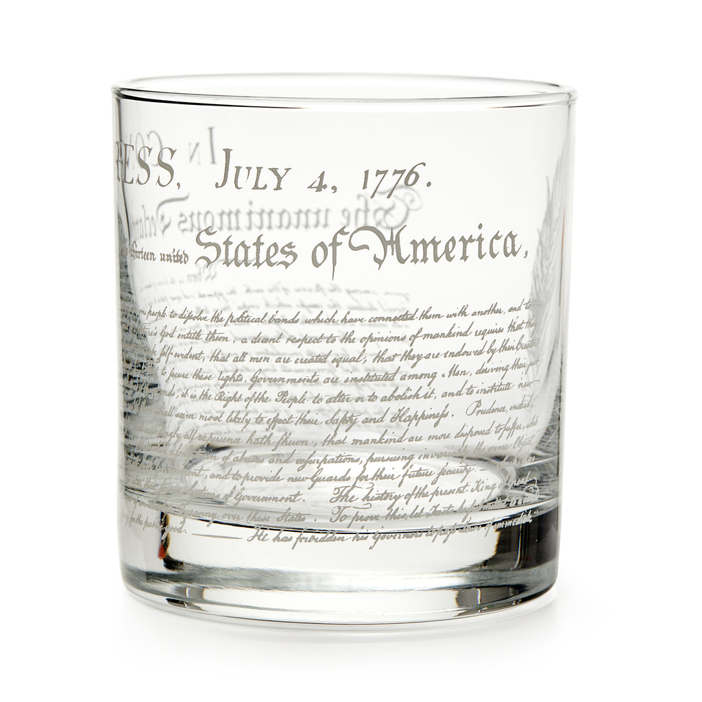 The Declaration of Independence Whiskey Glass features etched text like “July 4, 1776” and “United States of America” in decorative script—a unique patriotic gift, shown against a white background.