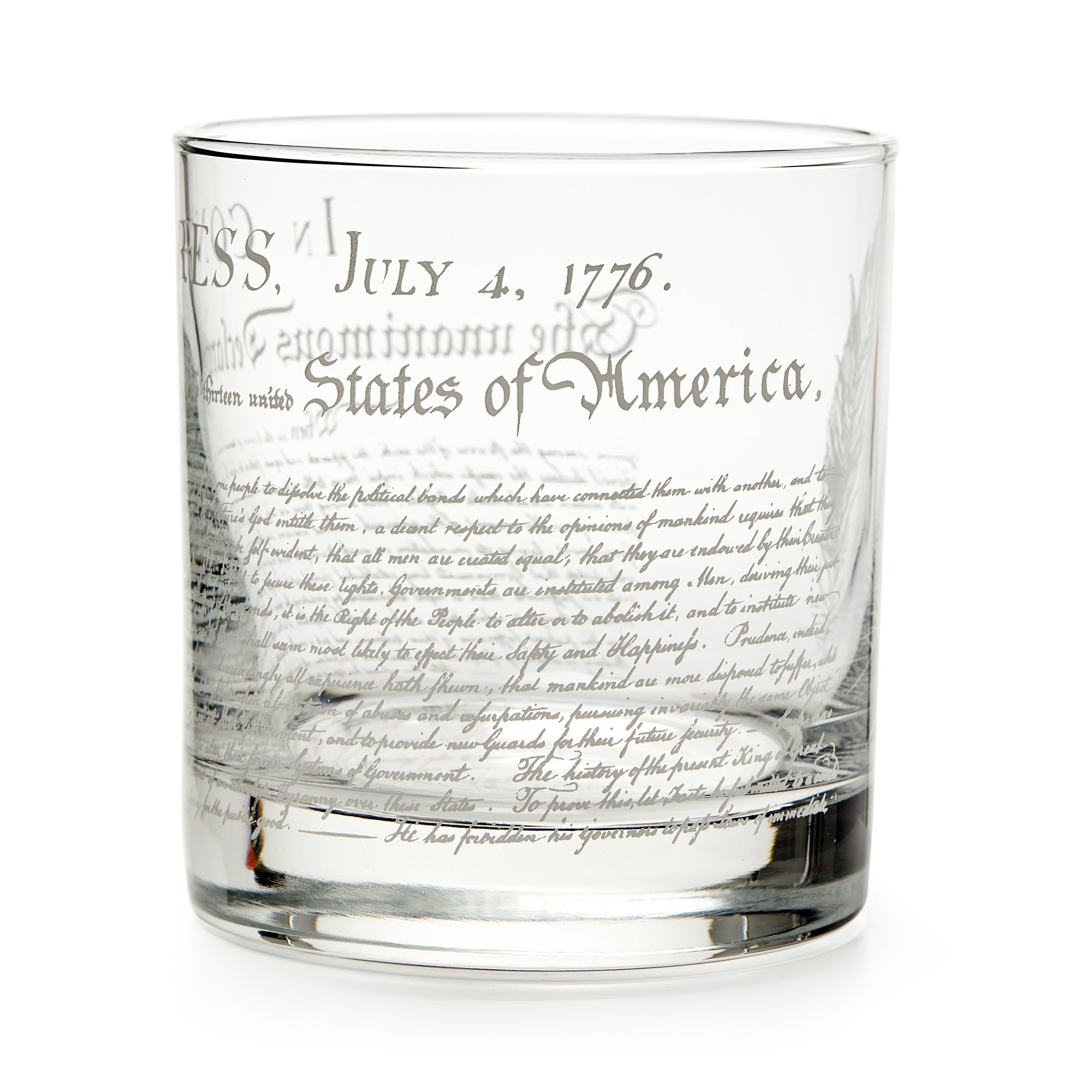 The Declaration of Independence Whiskey Glass features etched text like “July 4, 1776” and “United States of America” in decorative script—a unique patriotic gift, shown against a white background.