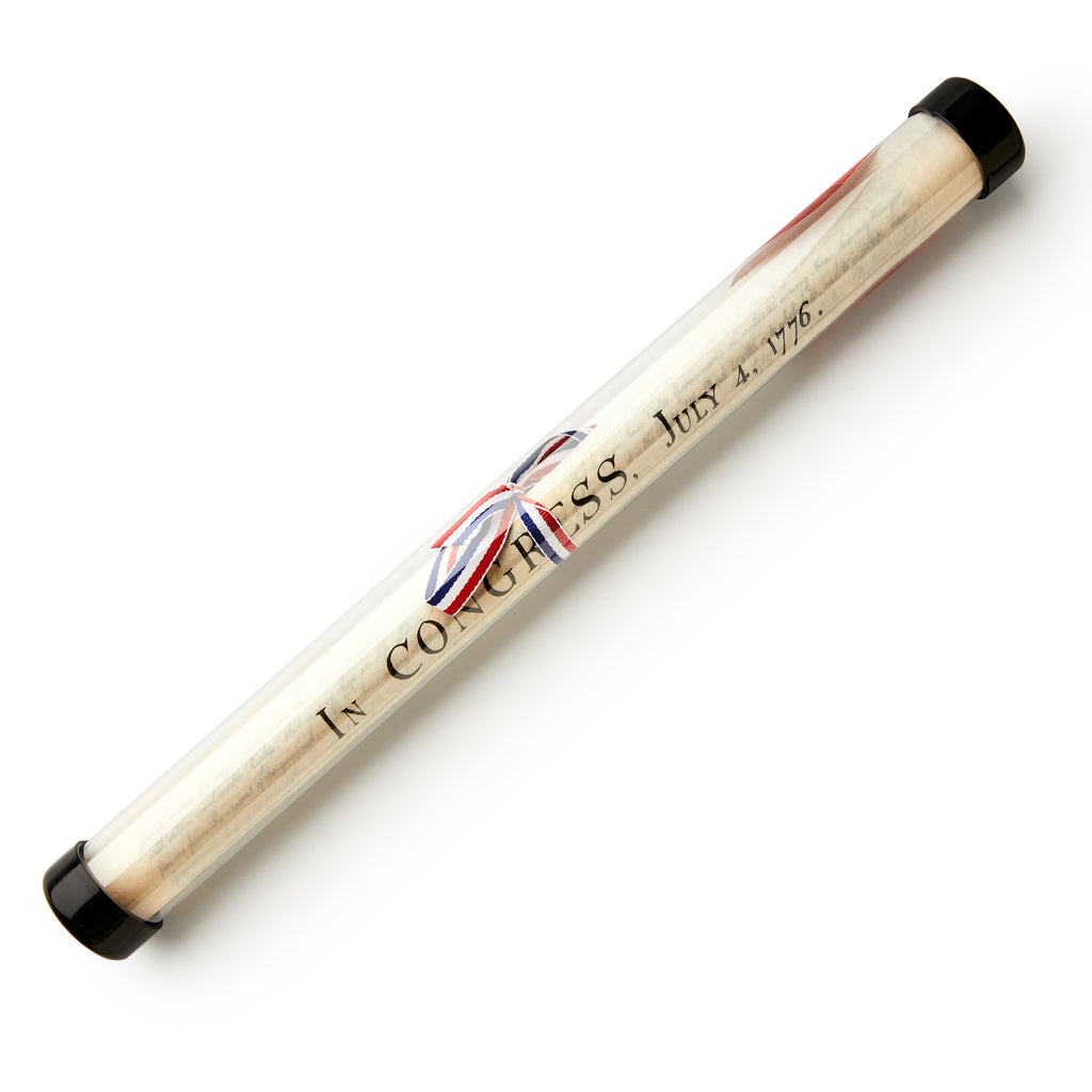 The Declaration of Independence Small Replica is a rolled document crafted to look like aged parchment paper and displayed in a clear tube with black end caps. Featuring visible text reading “IN CONGRESS, JULY 4, 1776,” this piece is tied with a ribbon in Union Jack colors, making it a distinctive addition to any patriotic collection or an ideal keepsake for those interested in the Declaration of Independence.