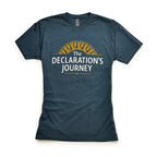 The Declaration's Journey T-Shirt features white "The Declaration’s Journey" text below a yellow sunburst on blue, displayed flat on white—ideal for commemorating the Declaration of Independence Semiquicentennial exhibition.