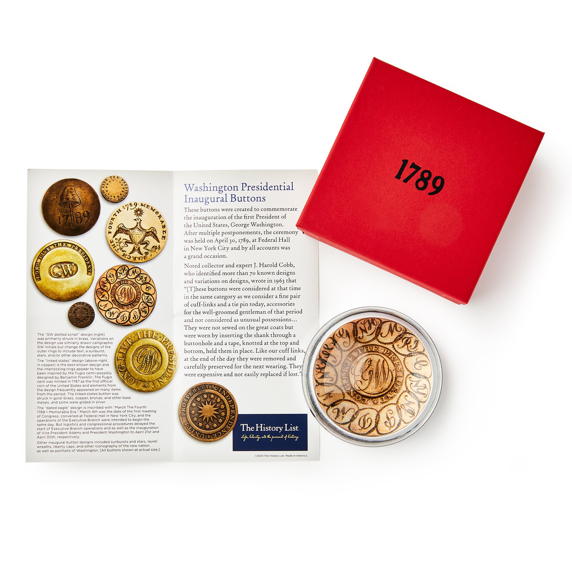 A display with a historical card features images of presidential inaugural buttons, a red box labeled 1789, and the GW Linked States Paperweight in a clear case with an eagle design.