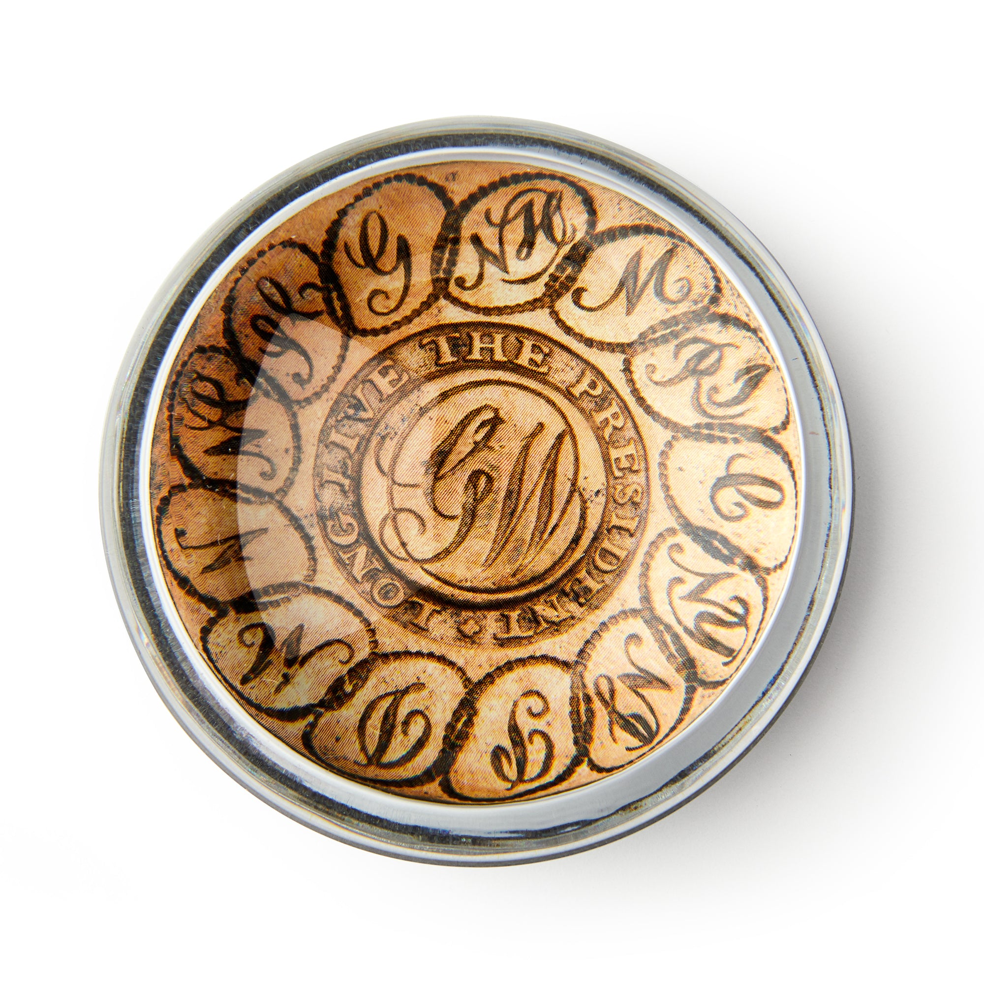 The GW Linked States Paperweight is round with an ornate "GW" monogram in the center, encircled by "Long live the president" in decorative script, and is shown from above on a white background.