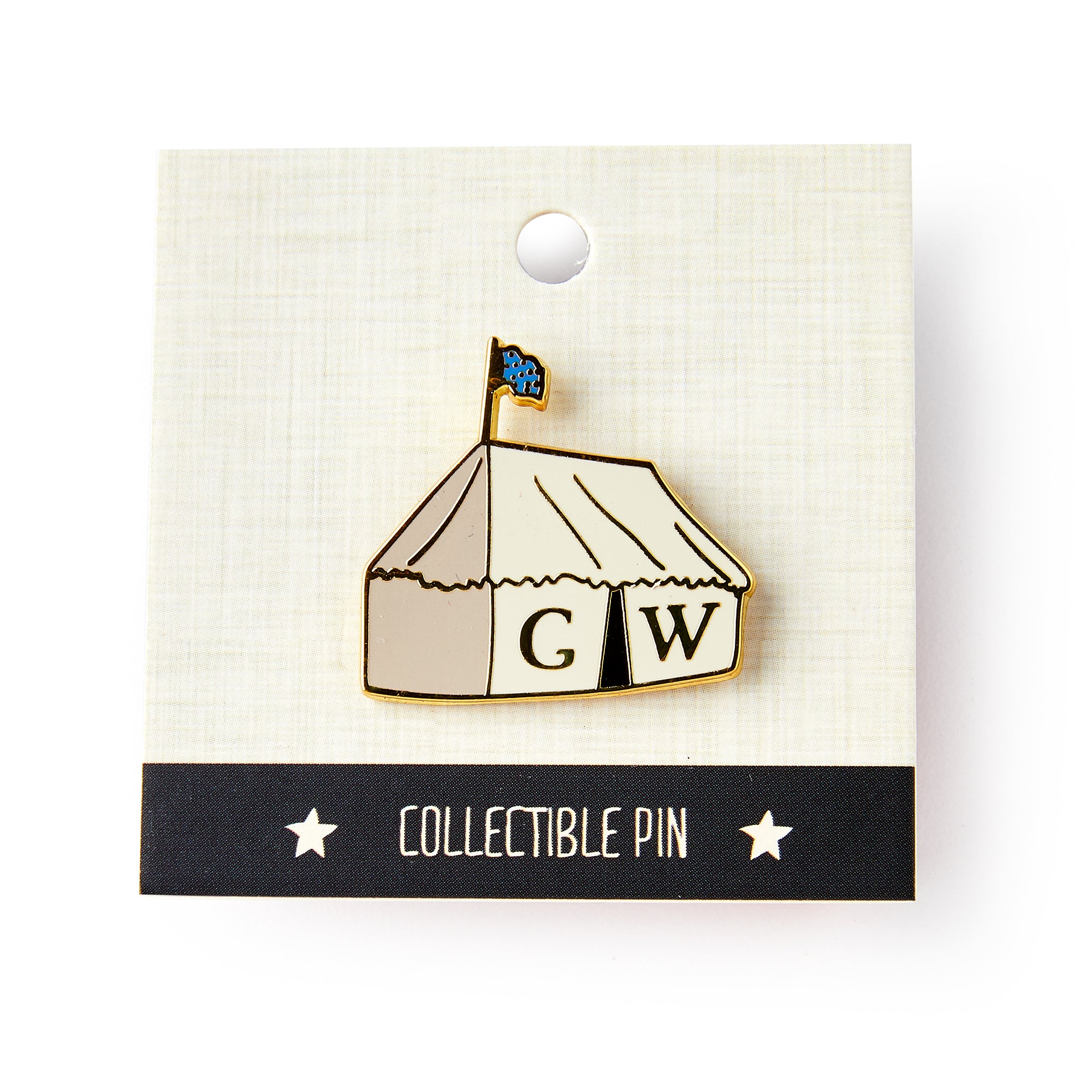 The George Washington Tent Pin is a white tent enamel pin with a blue flag and "G W" on the front, inspired by Washington's Revolutionary War tent. Presented on a collectible pin card with star accents.
