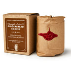 A brown box labeled Christopher Ludwick's Gingerbread Candle sits beside a cylindrical, brown-paper-wrapped package sealed with red wax—both radiate rustic, vintage charm and are perfect holiday gifts for home fragrance lovers.
