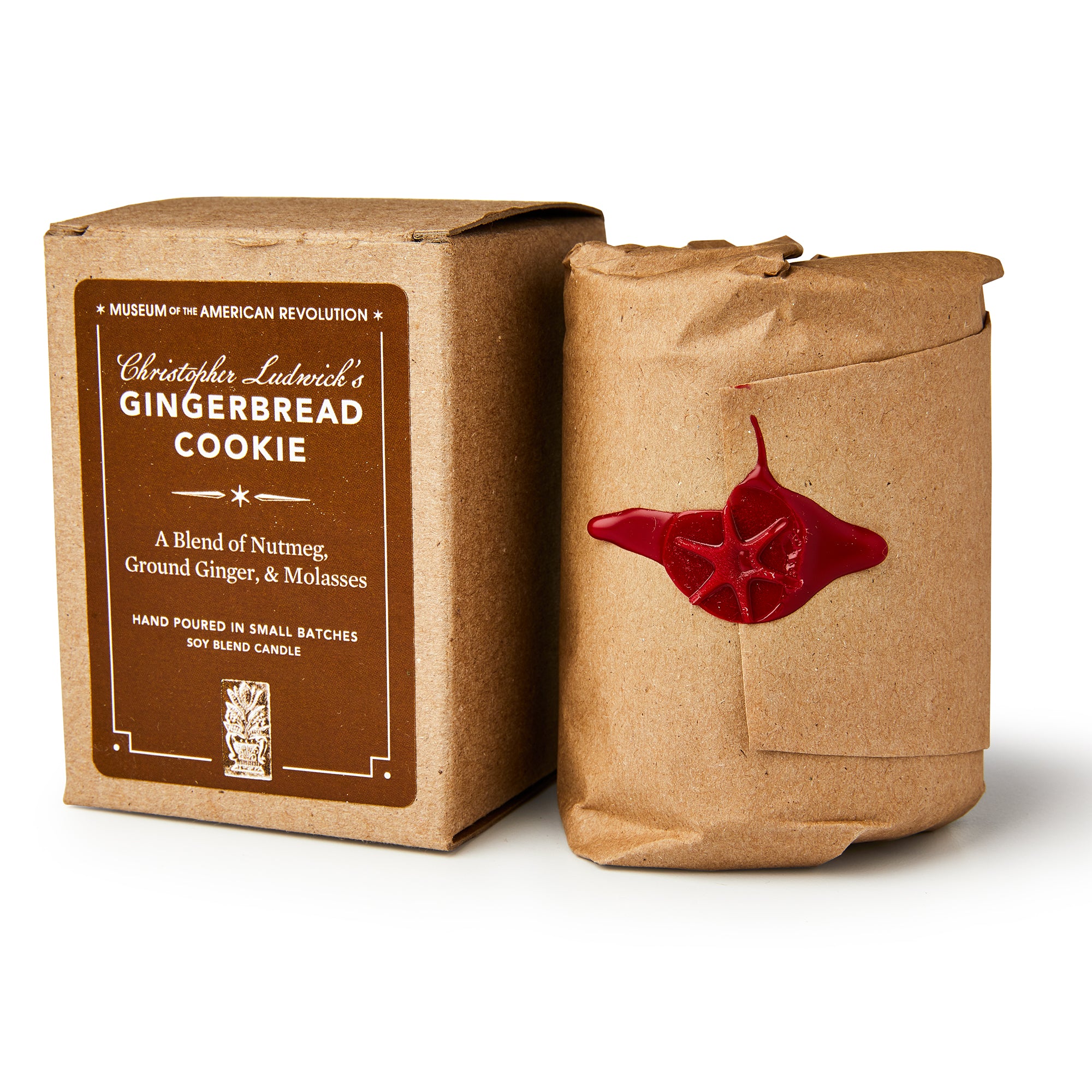 A brown box labeled Christopher Ludwick's Gingerbread Candle sits beside a cylindrical, brown-paper-wrapped package sealed with red wax—both radiate rustic, vintage charm and are perfect holiday gifts for home fragrance lovers.