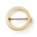 The Circle Brooch features a smooth, polished surface and minimalist design in gold, making it a versatile accessory. Shown against a white background.