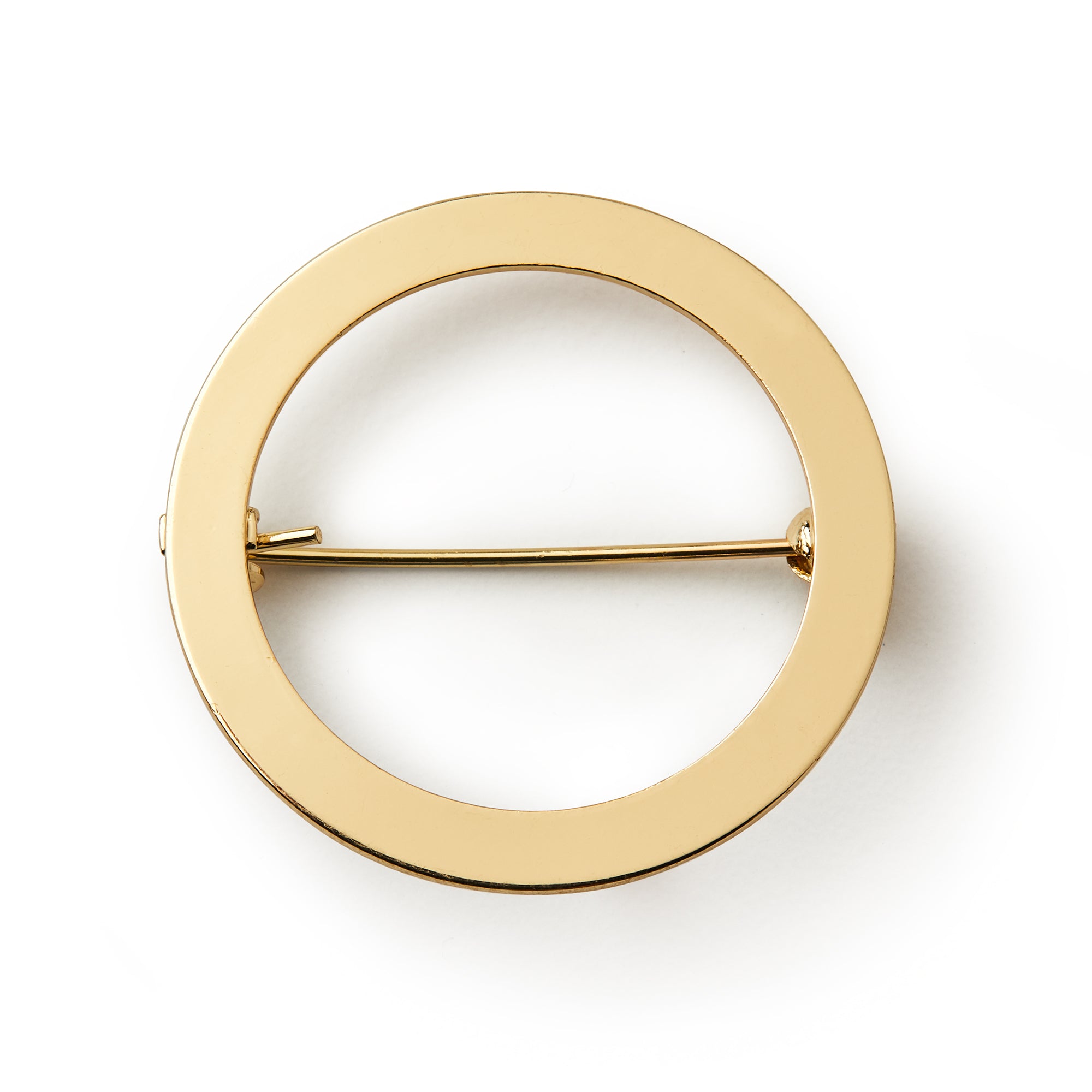 The Circle Brooch features a smooth, polished surface and minimalist design in gold, making it a versatile accessory. Shown against a white background.