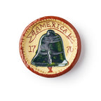 The Liberty Bell Plate, 3", is a round redware pottery piece with a raised Liberty Bell, "AMERICA," and "17" and "76," set on a cream background with a reddish-brown rim.