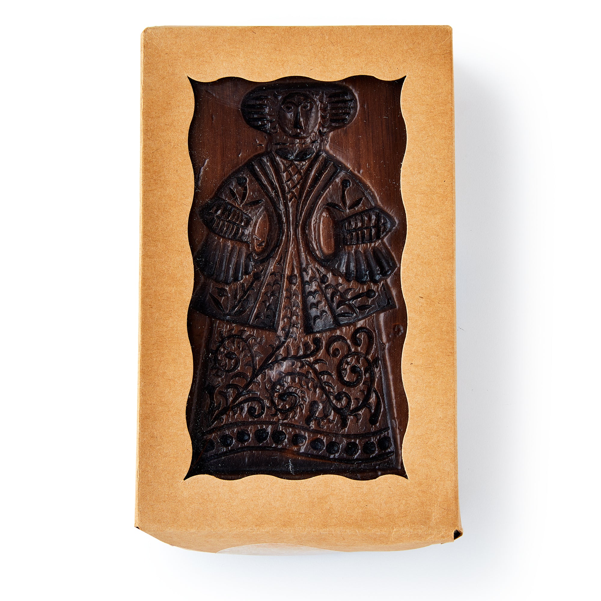 Wooden stamp with decorative design in craft paper packaging.