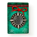 A pewter star-shaped ornament with a red ribbon, labeled Museum of the American Revolution, is displayed on green packaging that reads "Shining reflections of American heritage.