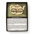 The No Stamp Act Earrings come in a box with an insert explaining the Stamp Act’s history. These round, cream-colored earrings feature ornate black designs and "No Stamp Act" text as a symbol of colonial protest.