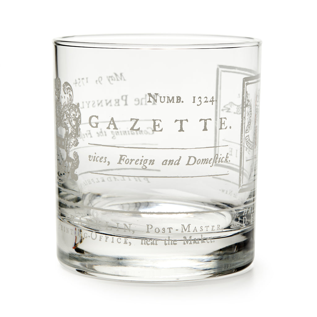 The Join or Die Whiskey Glass is a clear tumbler inspired by American history, featuring vintage-style printed text, decorative flourishes, old-fashioned fonts and numbers—evoking Benjamin Franklin’s era.
