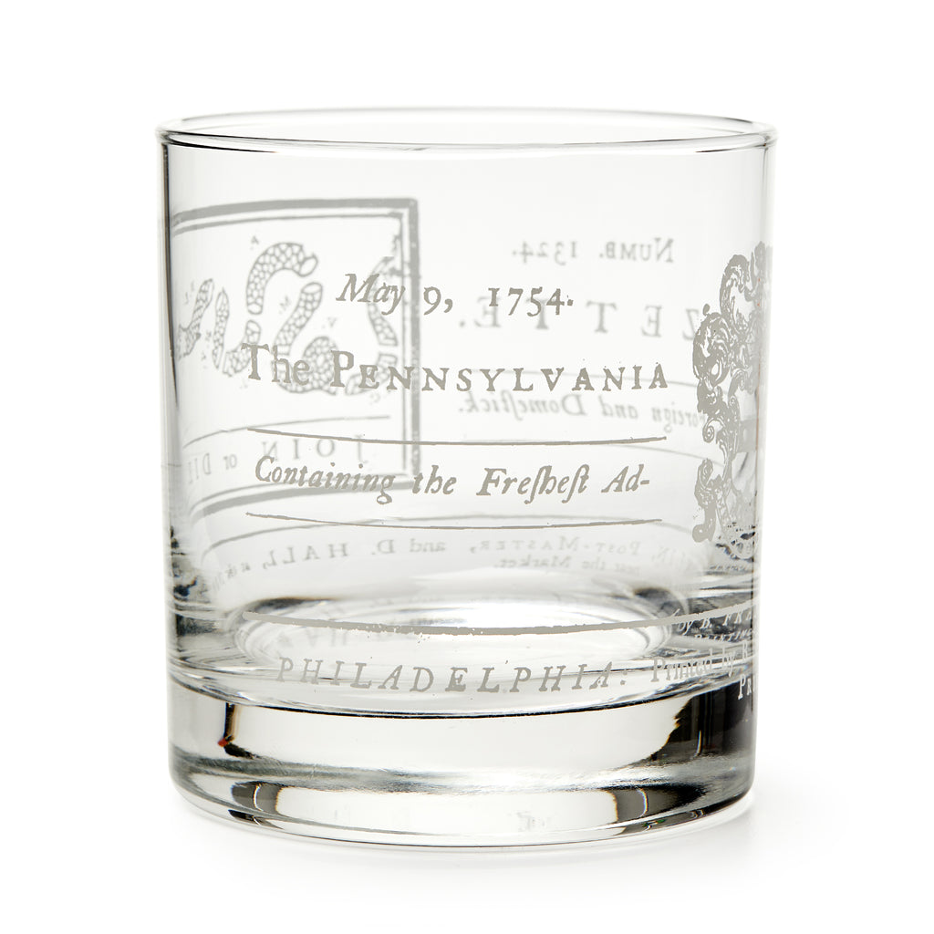 The Join or Die Whiskey Glass is a clear tumbler engraved with "May 9, 1754," Pennsylvania, and vintage motifs inspired by Benjamin Franklin’s iconic design—a unique tribute to American history.