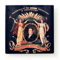 The Lafayette Parade Banner Sandstone Coaster features two allegorical women flanking a man’s portrait, with “Presented by the Victuallers of Philadelphia” above and “Columbia’s Honoured Guest” below; now at the Museum of the American Revolution.