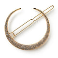 The Half Moon Barrette, Gold, features a crescent moon shape adorned with sparkling rhinestones. This shimmering crystal hair clip rests on a white background and makes a stunning gold hair accessory for any occasion.