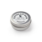 A small, round metal tin labeled Lip Balm Vanilla by Penny River sits closed on a white background. The lid features the text "historically inspired • all natural." This is a moisturizing tinted lip balm.