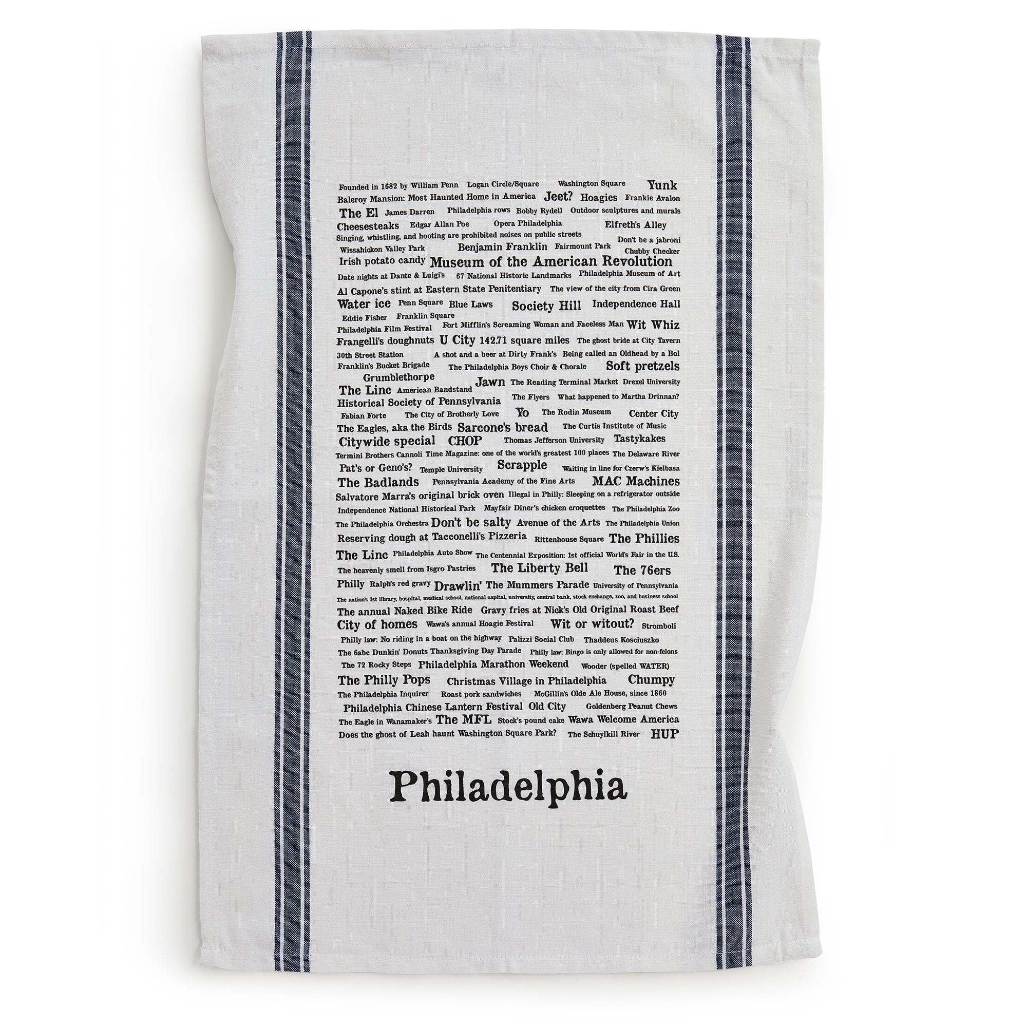 The Philadelphia Tea Towel features black typographic trivia about the city's landmarks, sports teams, foods, and neighborhoods. Handprinted with two vertical dark stripes on each side.