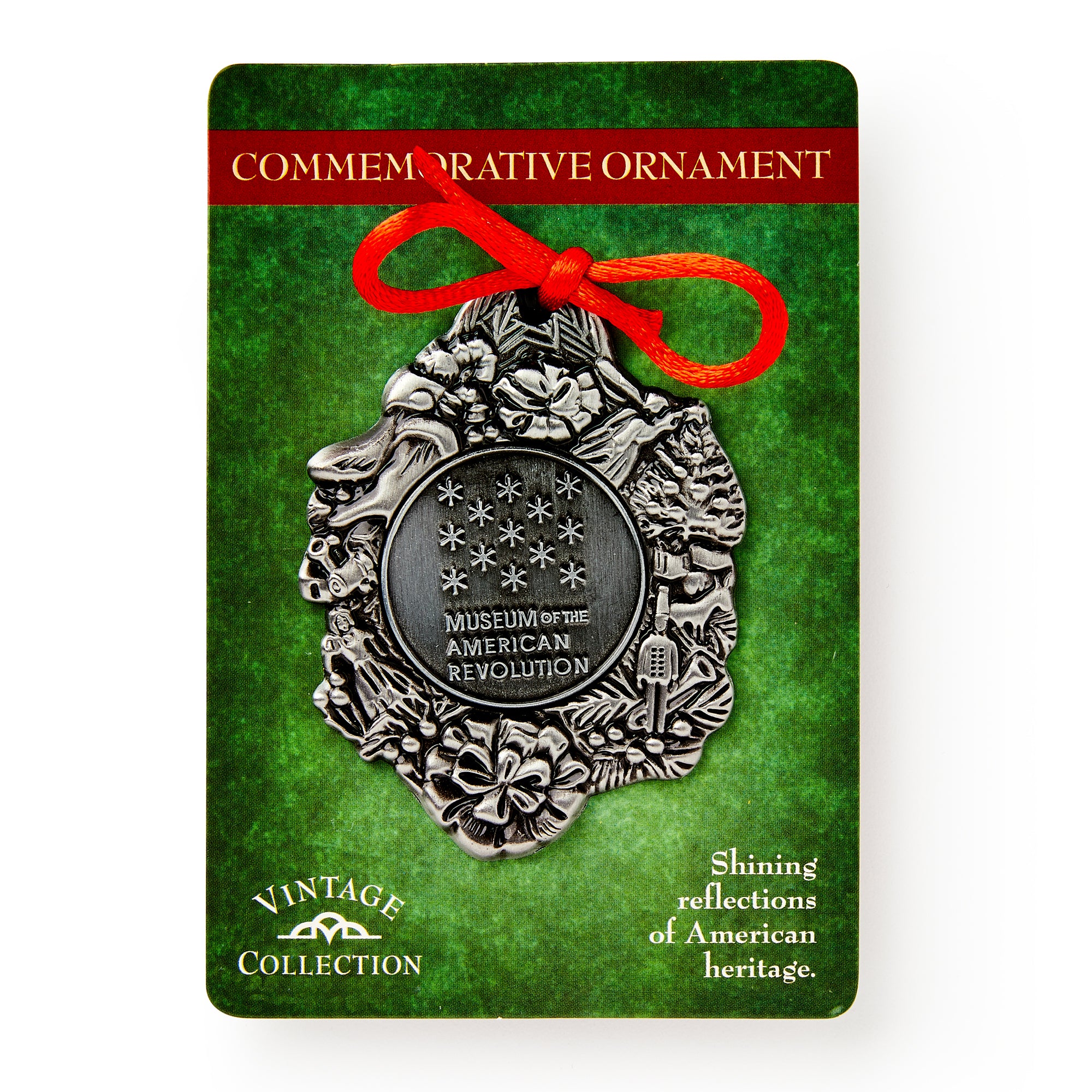 The Philadelphia Pewter Ornament features floral designs, stars, and "Museum of the American Revolution." This silver-tone ornament includes a red ribbon and comes on green Vintage Collection backing—perfect for celebrating American history.