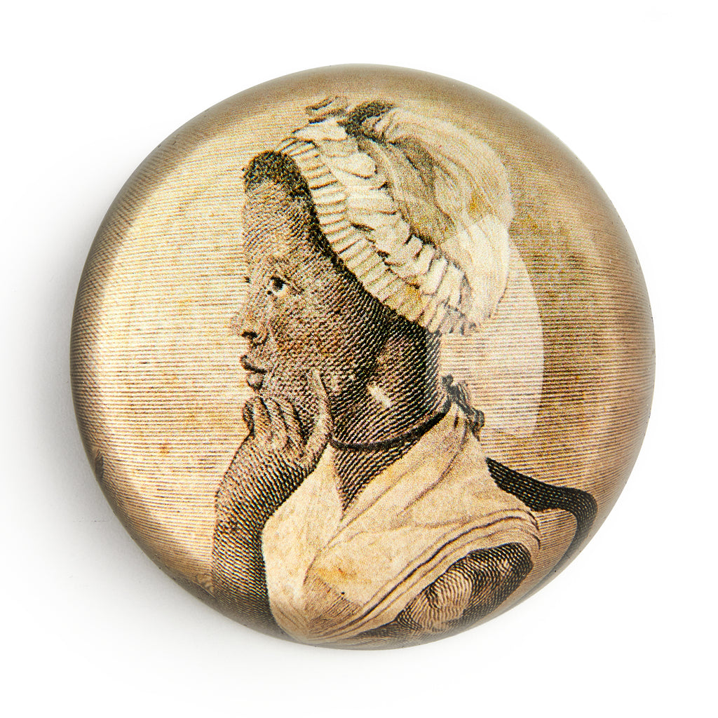 The Phillis Wheatley Glass Paperweight features a sepia-toned, vintage-style profile illustration of the African American poet with a headscarf, resting her chin on her hand against a plain white background.