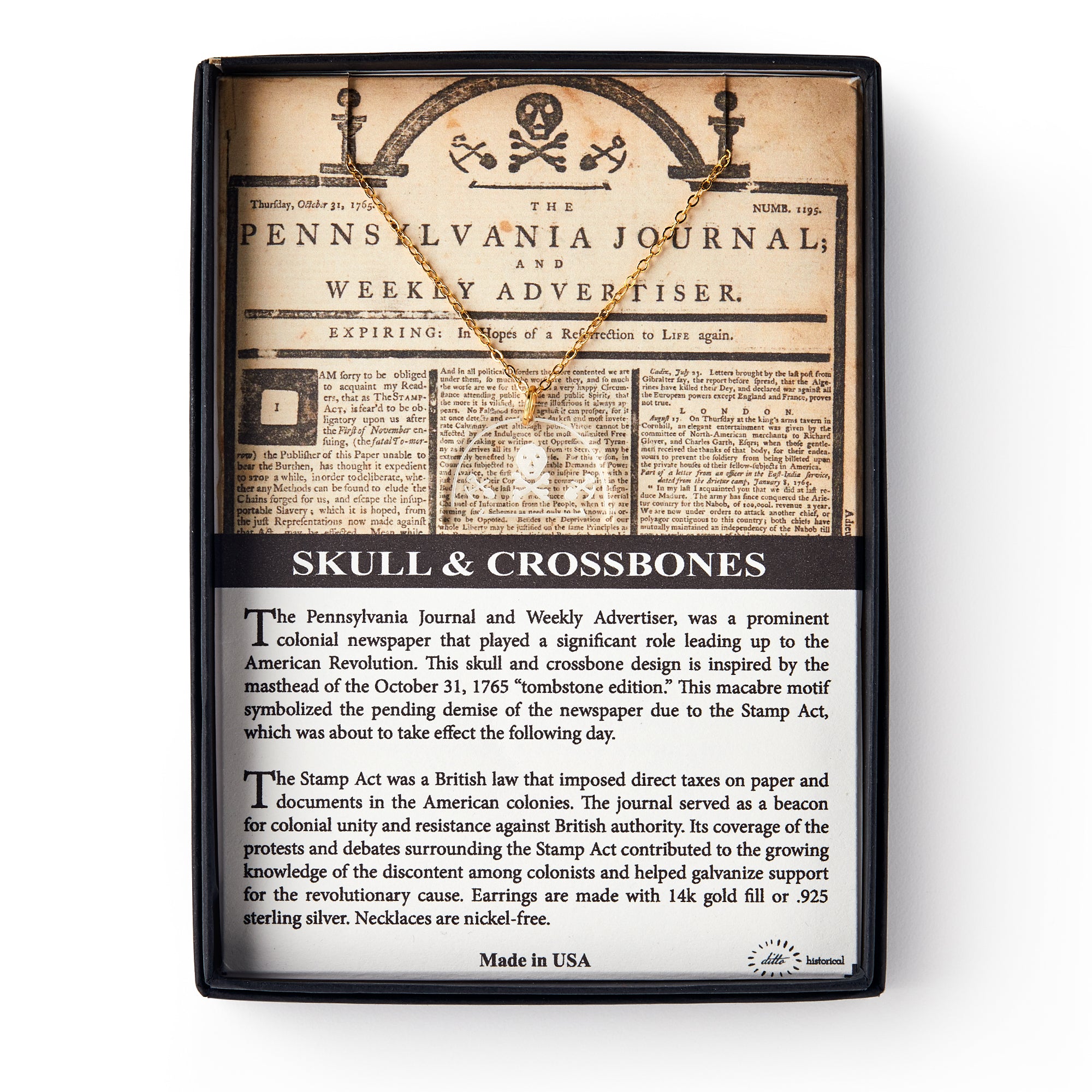 The Skull and Crossbones Necklace comes in a display box with a replica Pennsylvania Journal featuring the skull and crossbones image, colonial resistance details, and a gold necklace pendant shaped like a skull and crossbones.
