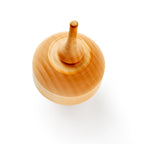 A Wooden Top is photographed from above on a white background, with motion blur around the edges emphasizing this handcrafted classic toy in action.