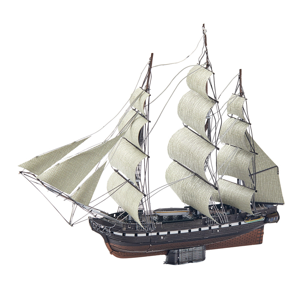 Model of a three-masted sailing ship with white sails on a white background