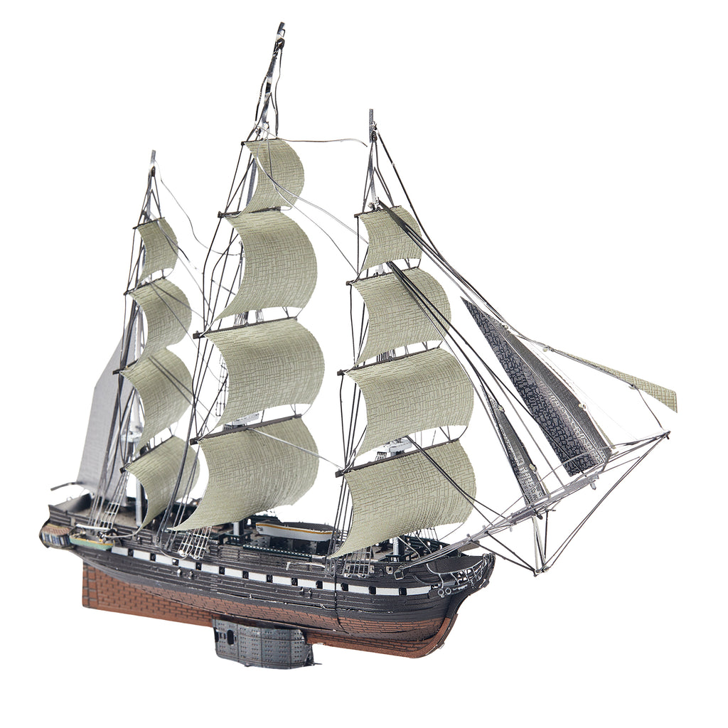 Model of a three-masted sailing ship with white sails on a white background
