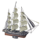 Model of a three-masted sailing ship with white sails on a white background