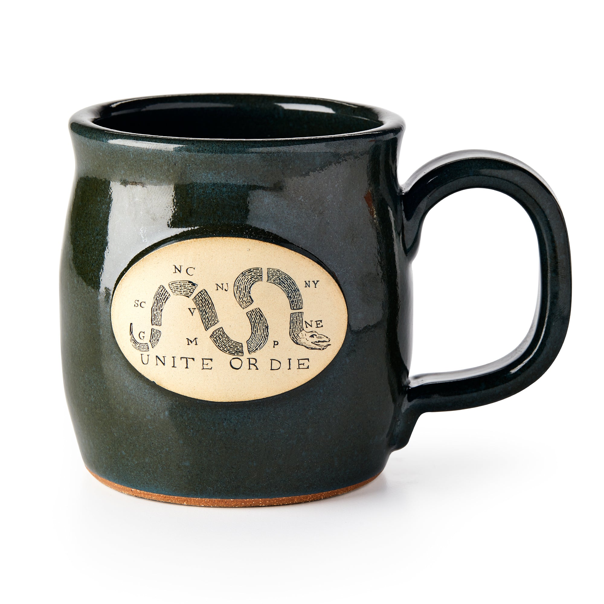 The Unite or Die Mug is a dark green ceramic cup featuring a tan oval emblem of a segmented snake with state abbreviations and "Unite or Die" beneath.