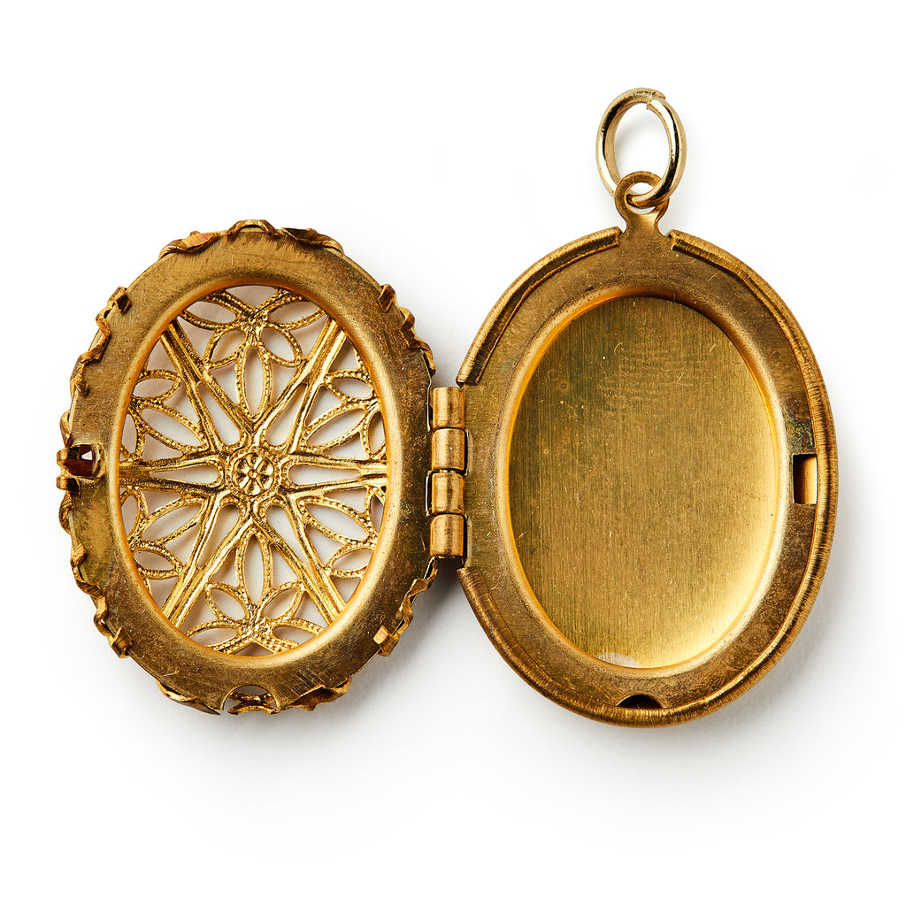 The Brass Open Work Locket features an open, oval-shaped brass design with ornate filigree on the left and a plain compartment on the right, shown against a white background—a vintage-inspired, elegant accessory.