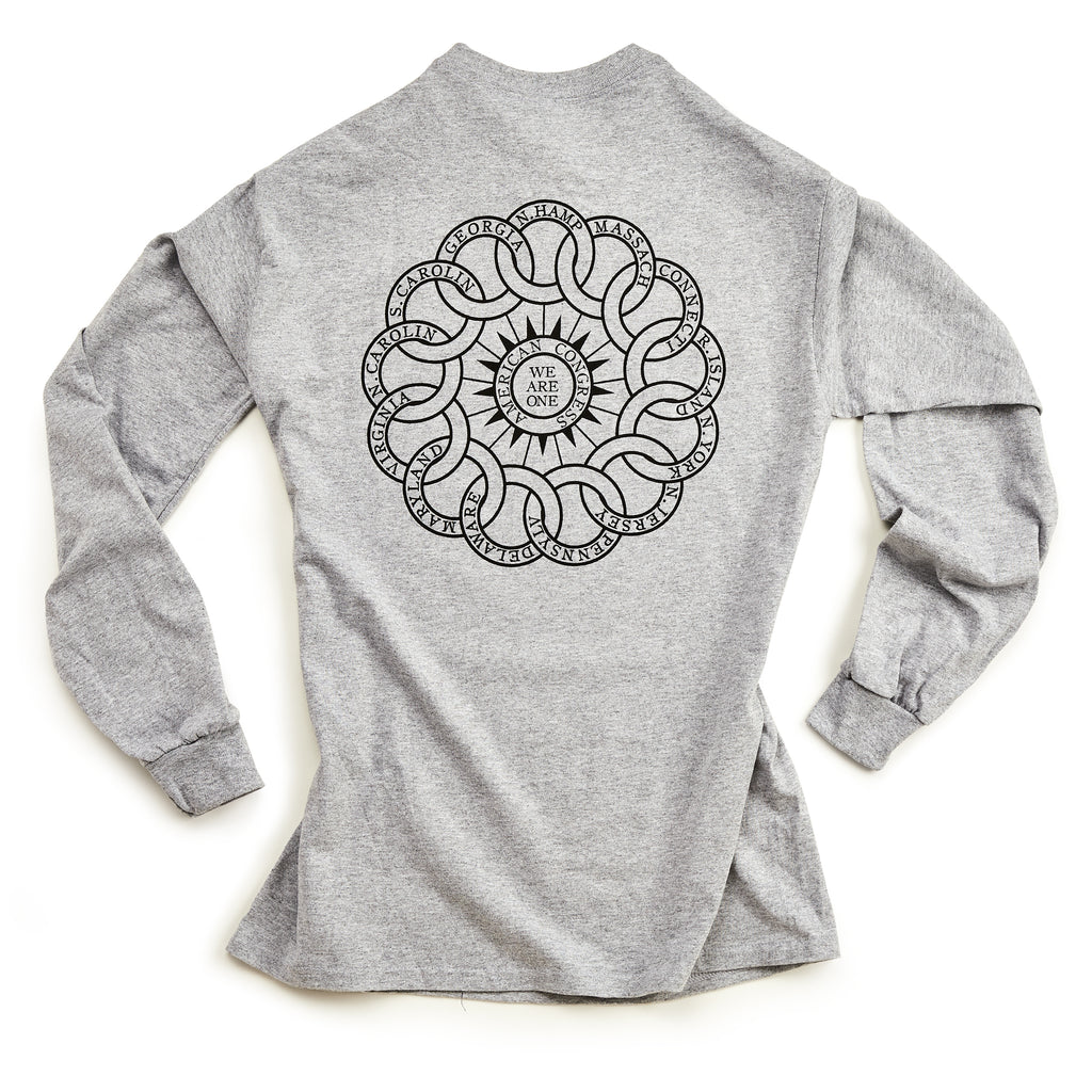 The Chain of States Long Sleeve T-Shirt in heather gray features a circular interwoven black line design and "WE ARE ONE" at the center on the back, inspired by themes from the Museum of the American Revolution—ideal for history enthusiasts.