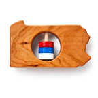 The Pennsylvania State Wooden Rattle is a handcrafted wooden baby toy shaped like Pennsylvania, with a circular cutout and spindle holding red, white, and blue rings.