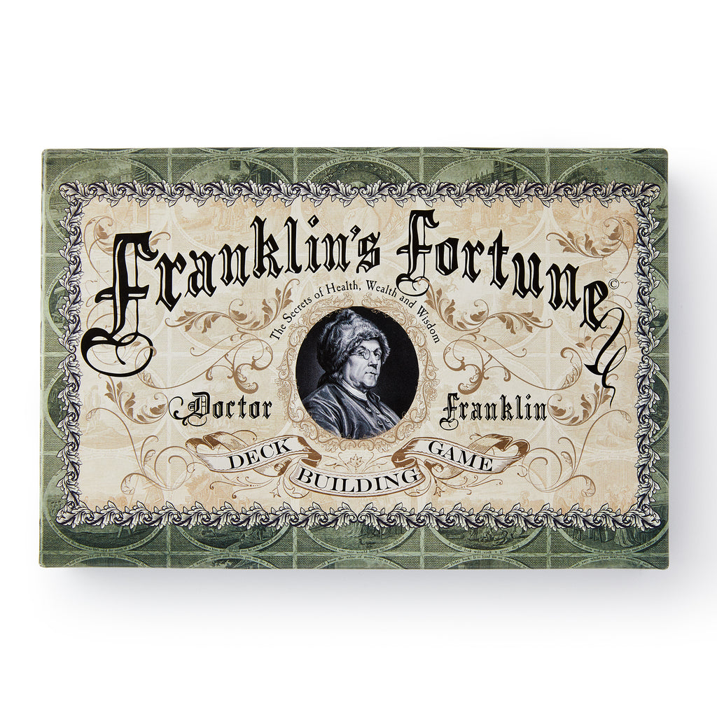 A decorative game box labeled “Franklin’s Fortune Deck Building Game,” adorned with ornate scrollwork and a central portrait of Benjamin Franklin.