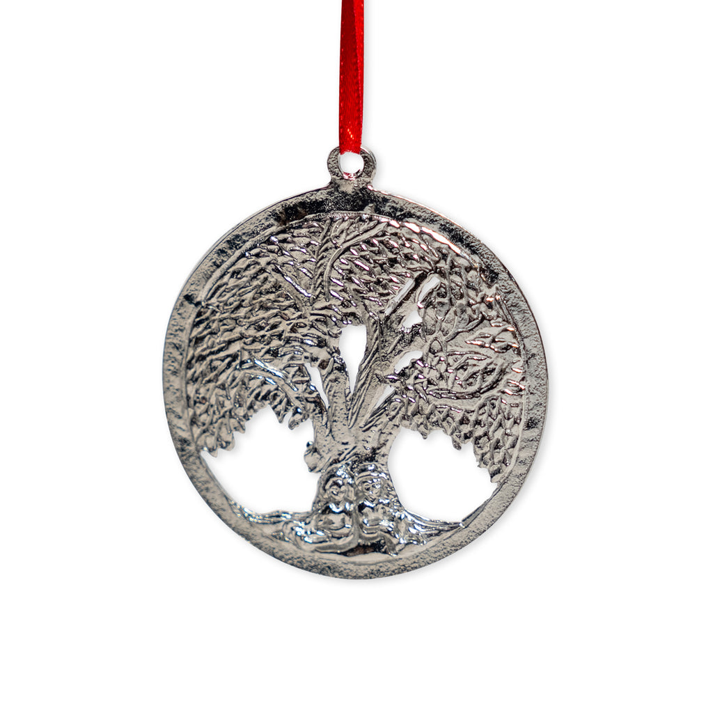 The Tree of Life Pewter Ornament is a round, handcrafted pewter piece featuring a detailed tree design and hangs from a red ribbon.