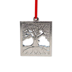 Introducing the Tree of Life Pewter Ornament—a handcrafted rectangular silver ornament made in North Carolina. Featuring a detailed tree of life design with visible roots and branches, this artisanal piece hangs elegantly from a red ribbon, beautifully showcasing expert craftsmanship.