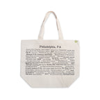 The Philadelphia Pride Ecotote is a beige cotton canvas tote bag featuring “Philadelphia, PA” at the top and black printed names of city landmarks, streets, and Philly trivia phrases arranged in various fonts and sizes. This Philadelphia tote includes two sturdy handles and a small green tag.