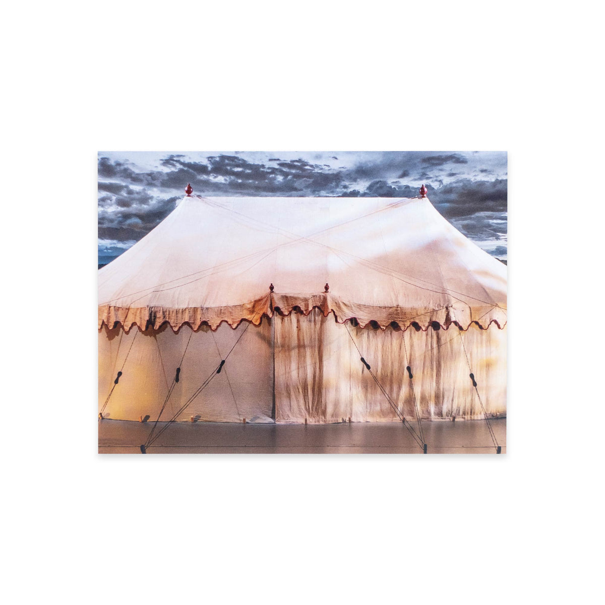 A large beige canvas tent with ropes and stakes sits under a cloudy sky, warmly lit from within—captured beautifully on the George Washington’s War Tent Postcard, evoking the legendary war tent preserved at the Museum of the American Revolution.