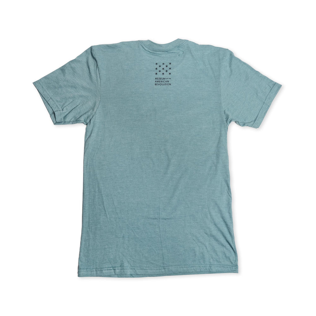 Light blue short-sleeve Remember the Ladies T-Shirt (MoAR) displayed flat with the back facing up. Small black text and a star pattern are printed near the neckline, offering a subtle tribute to women’s rights. The rest of this commemorative Abigail Adams tee remains plain.
