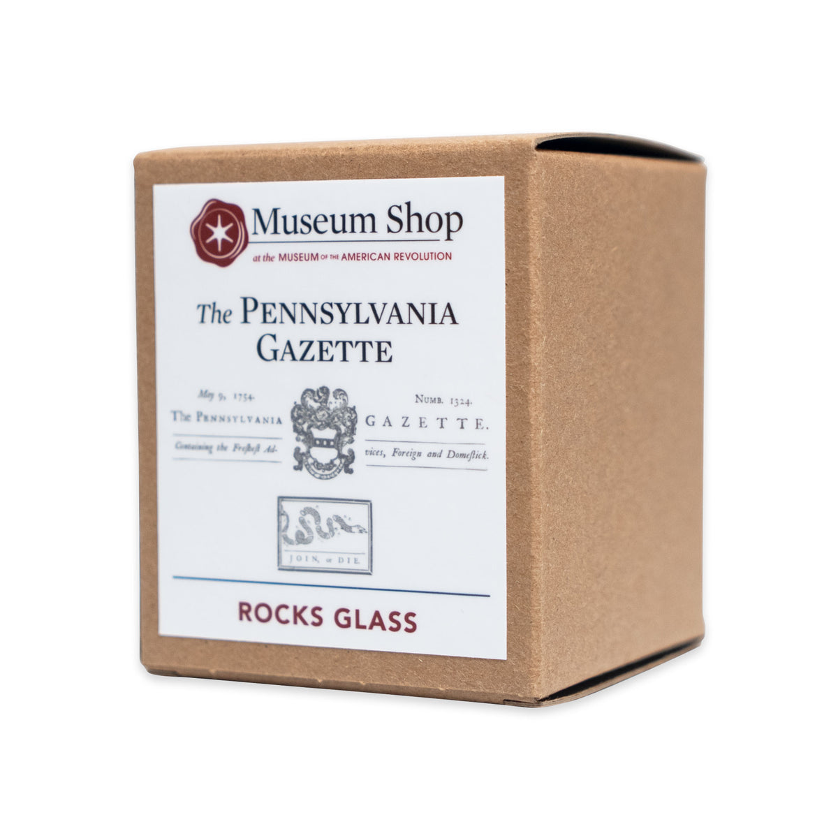 A Museum Shop cardboard box containing a Join or Die Whiskey Glass, featuring the Pennsylvania Gazette masthead and the iconic serpent illustration from American history.