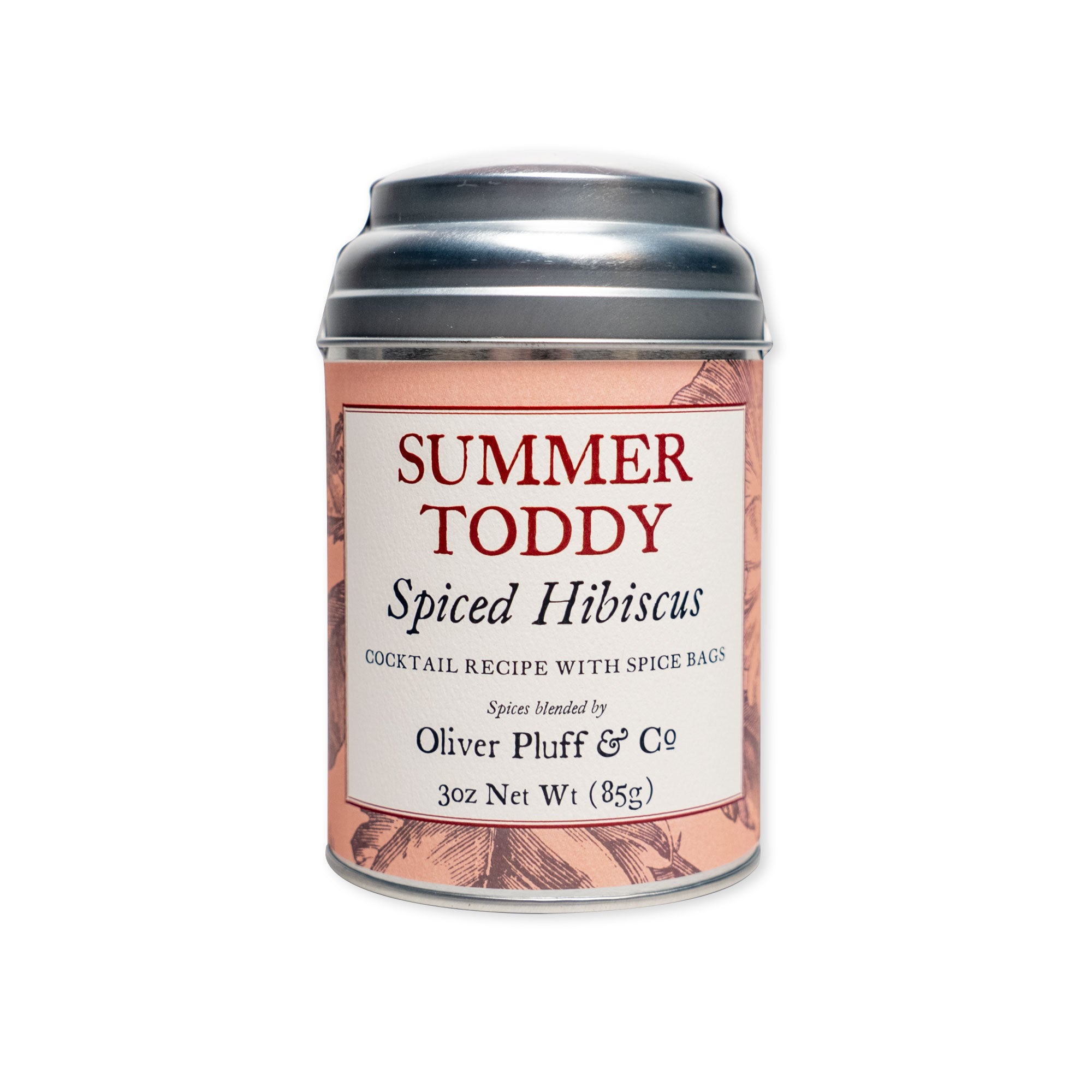 A cream and peach metal tin labeled "Summer Toddy, Spiced Hibiscus" by Oliver Pluff & Co. holds a 3 oz (85g) artisanal spice blend, featuring floral illustrations and cocktail recipe text—ideal for mixing a refreshing toddy or enhancing your favorite cocktails.