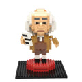 The Benjamin Franklin Mini Blocks set features a figurine with white hair, glasses, and brown clothes on a black and red base labeled "Benjamin Franklin," holding a white and black object—an ideal collectible for fans.