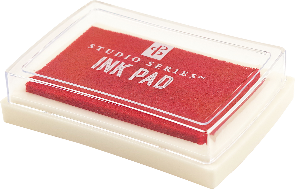 A rectangular red ink pad from the Studio Series Ink Pad Set, featuring a clear plastic lid and white base — perfect for scrapbooking — displayed on a plain background.