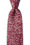 The Declaration of Independence Signers Silk Tie is a rich burgundy silk tie adorned with densely printed white, cursive signatures, evoking a formal and historic look inspired by the original signers of the Declaration of Independence.