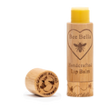 A wooden tube of Pomegranate Mango Lip Balm with its cap off beside it. The label shows a bee and heart, while the cap is engraved with "Pomegranate & Mango Handmade"—a nourishing beeswax lip balm.